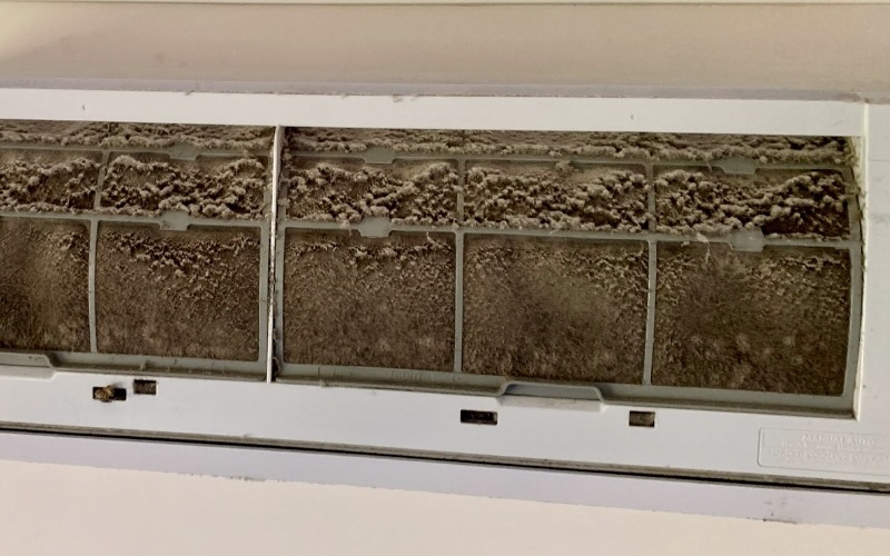 Heavily blocked split system aircon filter caked in dust and debris