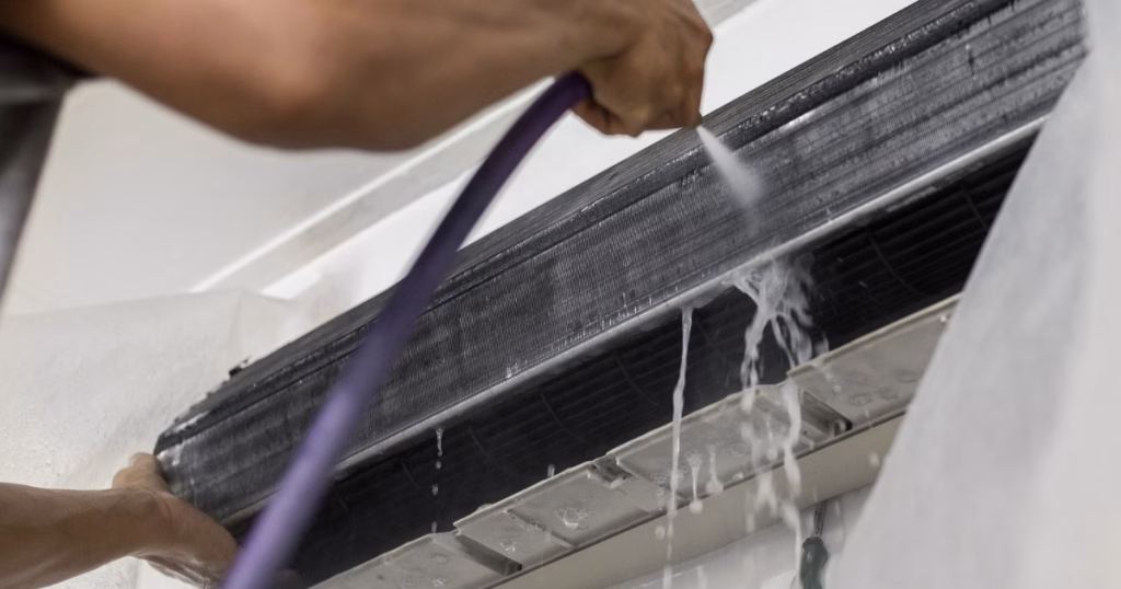 aircon maintenance brisbane - technician flushing a split system coil during a service
